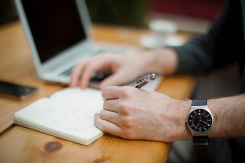 man writing on notepad